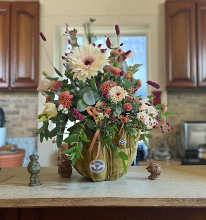 Green velvet pumpkin with fresh flower arrangement